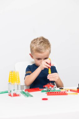 Metal inşaat setinde küçük bir çocuk oynanıyor. Beş yıl.