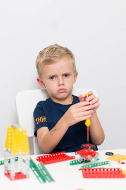 Metal inşaat setinde küçük bir çocuk oynanıyor. Beş yıl.