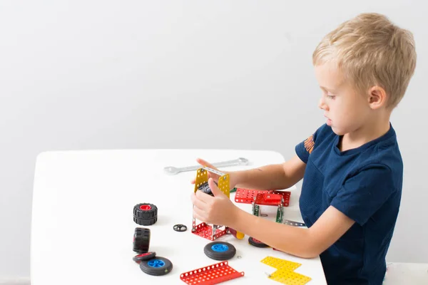 Metal inşaat setinde küçük bir çocuk oynanıyor. Beş yıl.