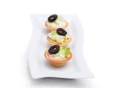 Tabağa dizilmiş bir sürü renkli kanepe var. Beyaz bir fuayede beyaz bir meşalede kanapeler