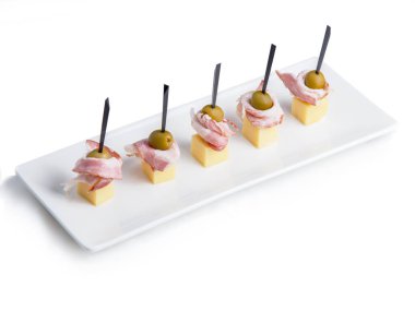 Tabağa dizilmiş bir sürü renkli kanepe var. Beyaz bir fuayede beyaz bir meşalede kanapeler