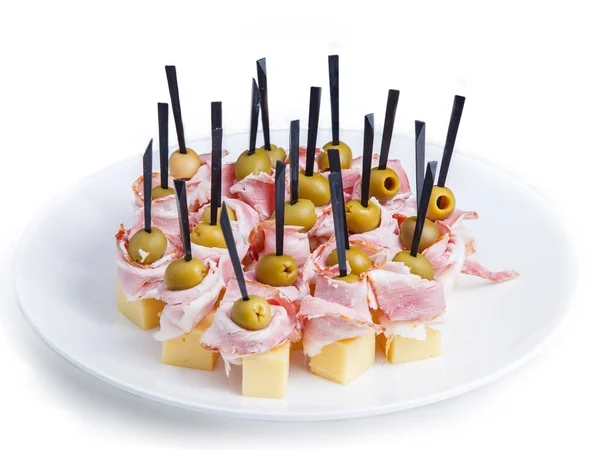 Tabağa dizilmiş bir sürü renkli kanepe var. Beyaz bir fuayede beyaz bir meşalede kanapeler