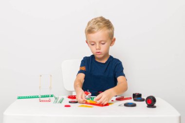 Dikiş, el işi. Küçük çocuk metalden bir çocuk tasarımcısı topluyor.