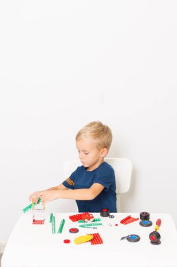 Dikiş, el işi. Küçük çocuk metalden bir çocuk tasarımcısı topluyor.