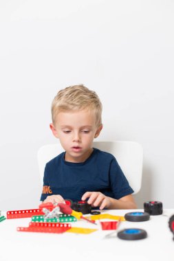 Dikiş, el işi. Küçük çocuk metalden bir çocuk tasarımcısı topluyor.