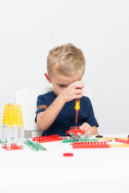 Dikiş, el işi. Küçük çocuk metalden bir çocuk tasarımcısı topluyor.