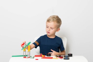 Dikiş, el işi. Küçük çocuk metalden bir çocuk tasarımcısı topluyor.