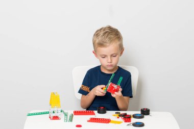 Dikiş, el işi. Küçük çocuk metalden bir çocuk tasarımcısı topluyor.