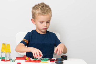 Dikiş, el işi. Küçük çocuk metalden bir çocuk tasarımcısı topluyor.