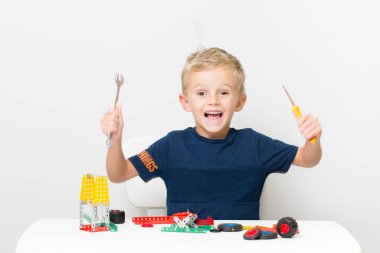 Dikiş, el işi. Küçük çocuk metalden bir çocuk tasarımcısı topluyor.