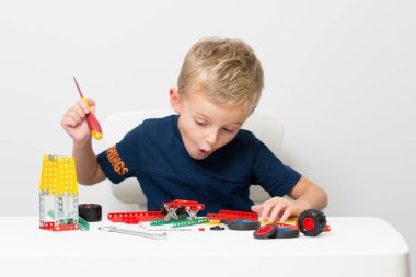 Dikiş, el işi. Küçük çocuk metalden bir çocuk tasarımcısı topluyor.