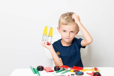 Dikiş, el işi. Küçük çocuk metalden bir çocuk tasarımcısı topluyor.