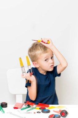 Dikiş, el işi. Küçük çocuk metalden bir çocuk tasarımcısı topluyor.