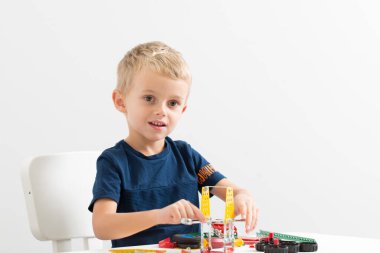 Dikiş, el işi. Küçük çocuk metalden bir çocuk tasarımcısı topluyor.