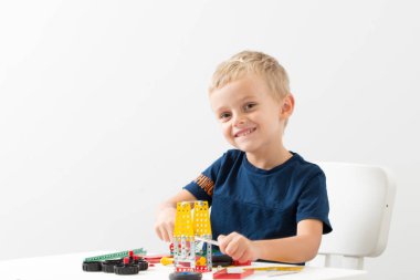 Dikiş, el işi. Küçük çocuk metalden bir çocuk tasarımcısı topluyor.