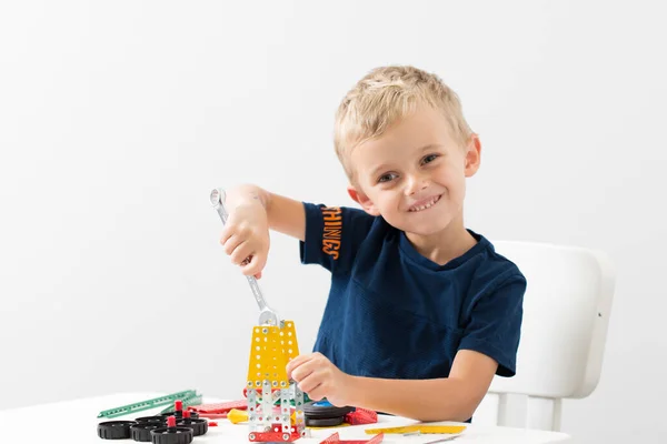 Dikiş, el işi. Küçük çocuk metalden bir çocuk tasarımcısı topluyor.