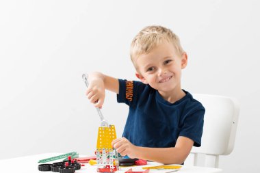 Küçük bir çocuk metalden çocuk tasarımcısı topluyor. Beş yaşında bir çocuk bir inşaatçı topluyor.