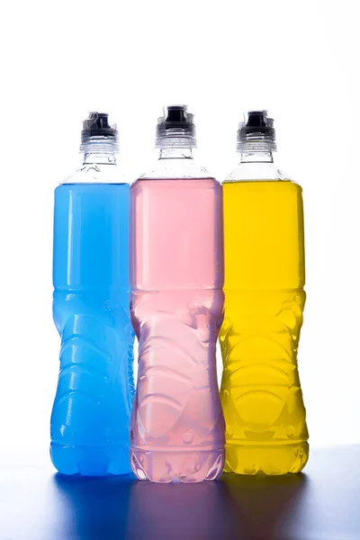 Plastic bottles with colored liquid. Colored bottles of sports nutrition, isotonics.