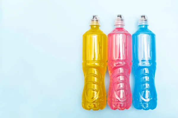 Plastic bottles with colored liquid. Colored bottles of sports nutrition, isotonics.