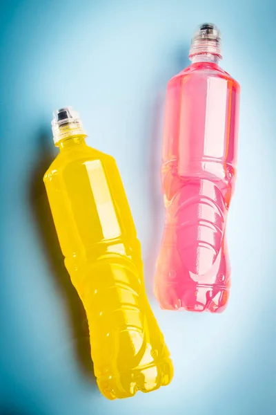 Plastic bottles with colored liquid. Colored bottles of sports nutrition, isotonics.