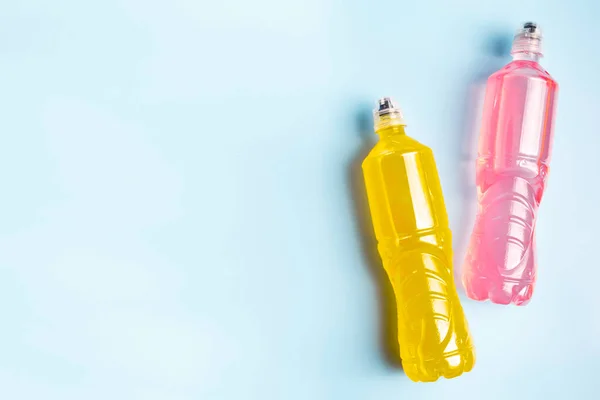 Plastic bottles with colored liquid. Colored bottles of sports nutrition, isotonics.