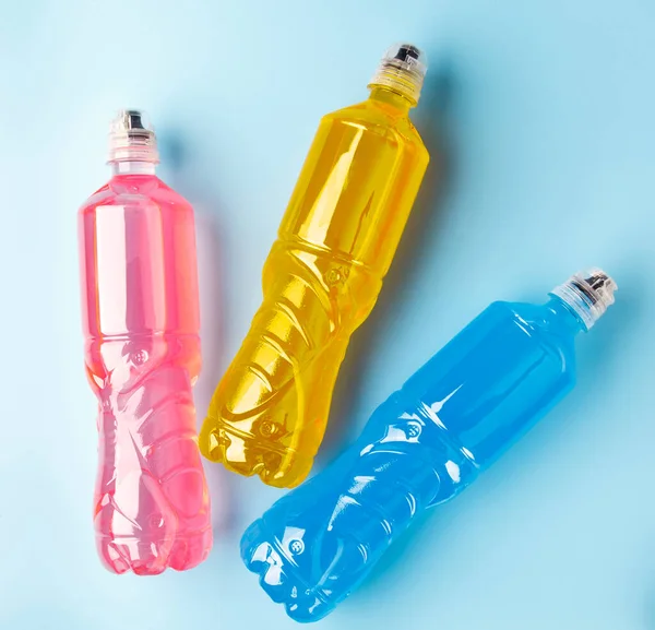 Plastic bottles with colored liquid. Colored bottles of sports nutrition, isotonics.
