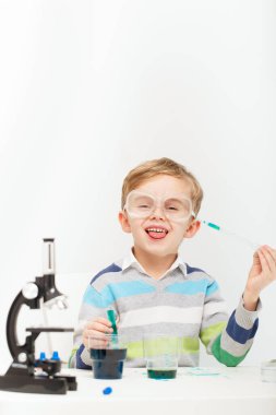 Çocuk beş yaşında, renkli sıvılarla deney yapıyor. Avrupa görünümlü küçük bir bilim adamının kimyasal deneyleri..