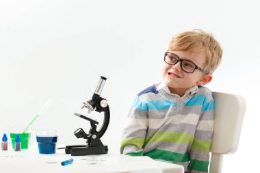 Çocuk beş yaşında, renkli sıvılarla deney yapıyor. Avrupa görünümlü küçük bir bilim adamının kimyasal deneyleri..