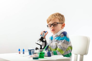 Çocuk beş yaşında, renkli sıvılarla deney yapıyor. Avrupa görünümlü küçük bir bilim adamının kimyasal deneyleri..