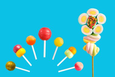 Çubukta çok renkli şekerler, mavi arkaplan. Mavi arka planda çok renkli lolipoplar (Chyupa-Chyup 'lar)