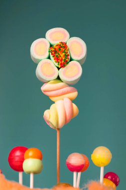 Çubukta çok renkli şekerler, mavi arkaplan. Mavi arka planda çok renkli lolipoplar (Chyupa-Chyup 'lar)