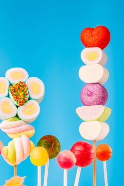 Çubukta çok renkli şekerler, mavi arkaplan. Mavi arka planda çok renkli lolipoplar (Chyupa-Chyup 'lar)