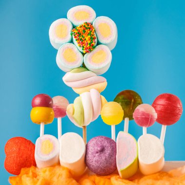 Çubukta çok renkli şekerler, mavi arkaplan. Mavi arka planda çok renkli lolipoplar (Chyupa-Chyup 'lar)