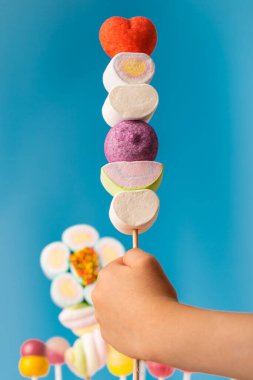 Çubukta çok renkli şekerler, mavi arkaplan. Mavi arka planda çok renkli lolipoplar (Chyupa-Chyup 'lar)