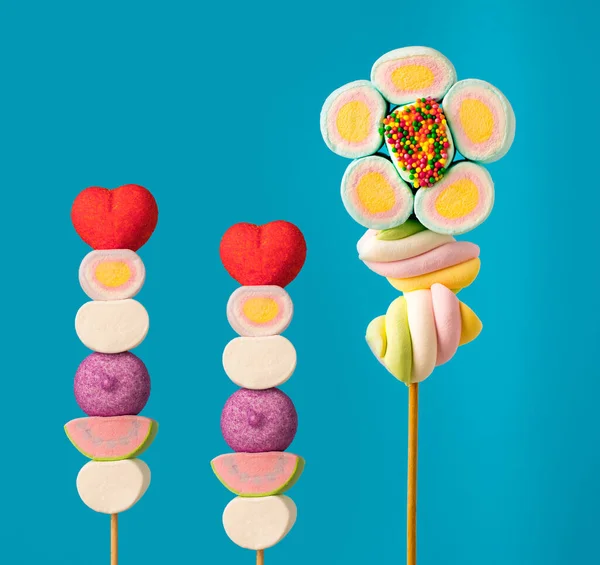 Çubukta çok renkli şekerler, mavi arkaplan. Mavi arka planda çok renkli lolipoplar (Chyupa-Chyup 'lar)