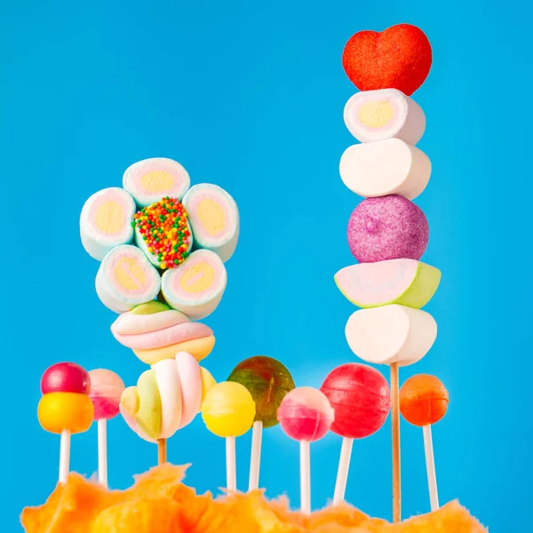 Çubukta çok renkli şekerler, mavi arkaplan. Mavi arka planda çok renkli lolipoplar (Chyupa-Chyup 'lar)