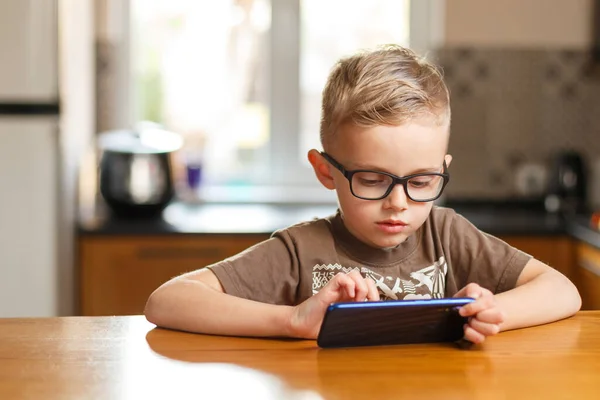 Çocuk, Avrupa 'nın gözlükleriyle yıllarca şarkı söylüyor. Telefonda konuşuyor. Çocuk, Avrupa 'nın gözlükleriyle yıllarca şarkı söylüyor. Mutfakta telefonla oynuyor.