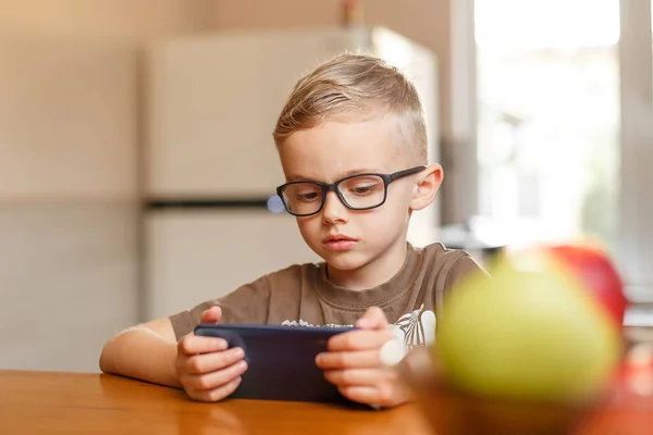 Çocuk, Avrupa 'nın gözlükleriyle yıllarca şarkı söylüyor. Telefonda konuşuyor. Çocuk, Avrupa 'nın gözlükleriyle yıllarca şarkı söylüyor. Mutfakta telefonla oynuyor.