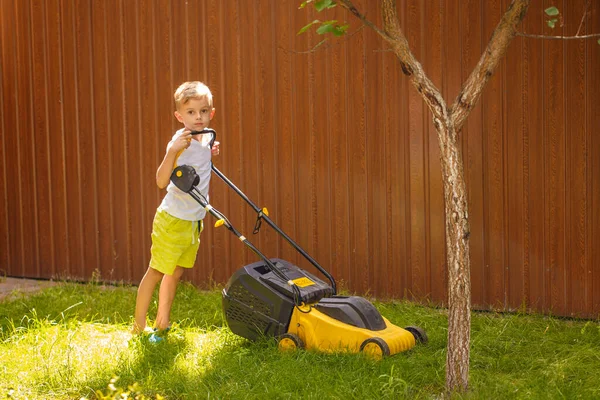 Blond Boy Mowing Lawn Garden Yellow Lawn Mower Sunny Summer — Stok fotoğraf