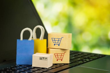 Çevrimiçi alışveriş veya teslimat hizmeti konsepti alışveriş çantası dizüstü bilgisayarda karton kutularla çevrimiçi internet siteleri Müşteriler her şeyi ofisten ya da evden satın alabilirler.