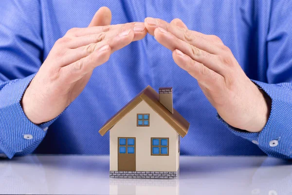 Страхування майна та концепція безпеки бізнесмен руки прикриває будинок — стокове фото