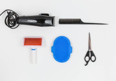 Köpeğin tımar edilmesi için hazırlandı. Saç makası, makas, taraklar beyaz arka planda. Kedi ya da köpek bakımı için aletleri kapatın. Hayvan bakımı