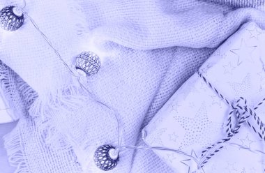 Kadınlar kışlık kıyafetleri ve aksesuarları çok Peri renginde yaparlar. Örgü süveter, kazak, eşarp, bej renkli pastel arka planda çelenkler. 2022 yılının moda rengi