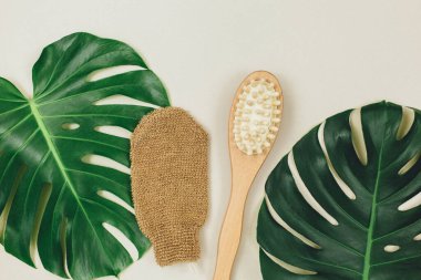 Havlu ve çiçek yaprağıyla kaplıca hayatı. Yüz ve vücut için masaj fırçalarını kapatın. Rahatlama, cilt bakımı, sağlık.