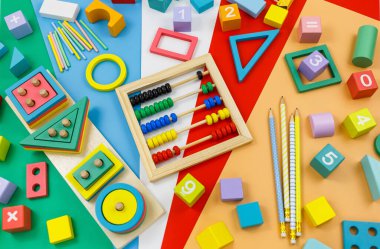 Kırmızı arka planda çok renkli ahşap bloklar. Moda bulmaca oyuncakları. Geometrik şekiller: kare, daire, üçgen, dikdörtgen. Anaokulu, anaokulu ya da kreş için eğitici oyuncaklar. Okula geri dön.