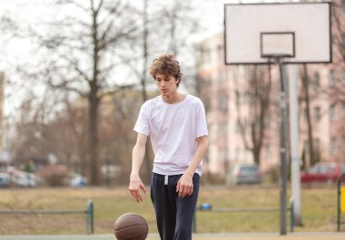 Beyazlar içinde top oynayan hoş bir genç kız. Spor, hobi, erkekler için aktif yaşam tarzı