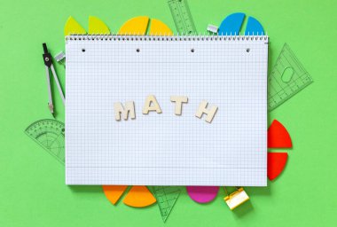 School supplies, open notepad, rulers, fractions on a green background. Interesting, fun math for kids. Education, back to school concept