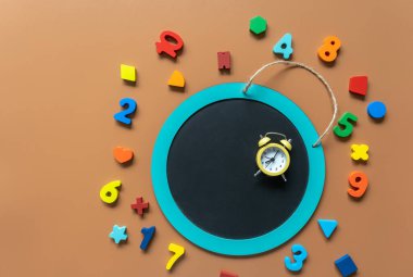 Closeup school board, mathematical fractions, pencils, notebook, ruler, accessories for school on brown table. Back to school, education background