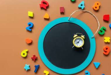 Closeup school board, mathematical fractions, pencils, notebook, ruler, accessories for school on brown table. Back to school, education background