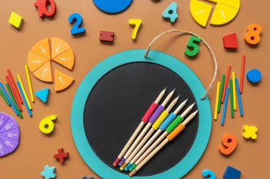 Closeup school board, mathematical fractions, pencils, notebook, ruler, accessories for school on brown table. Back to school, education background